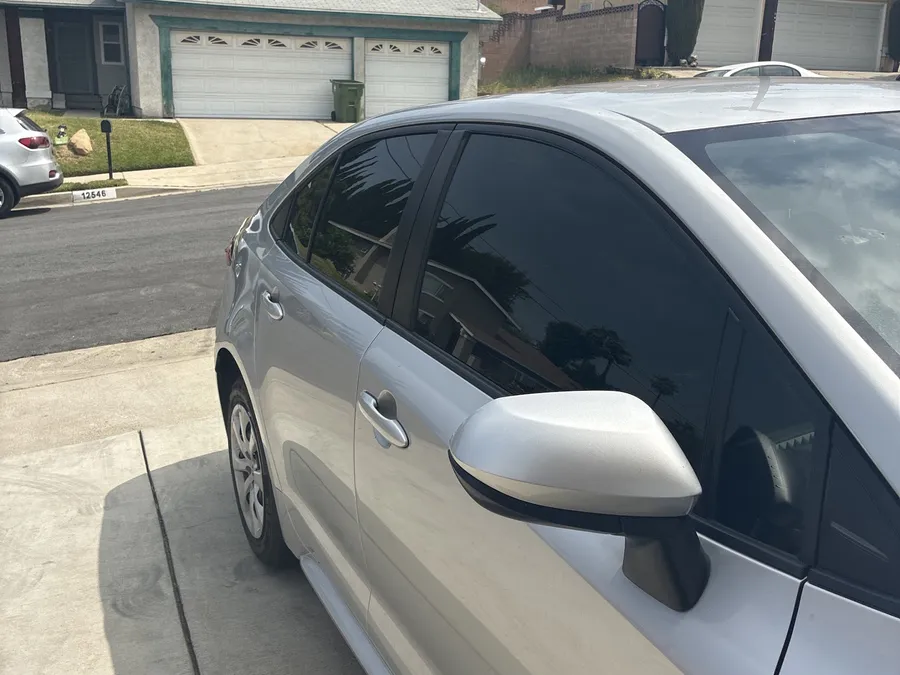 Silver Corolla hatchback with rear tint